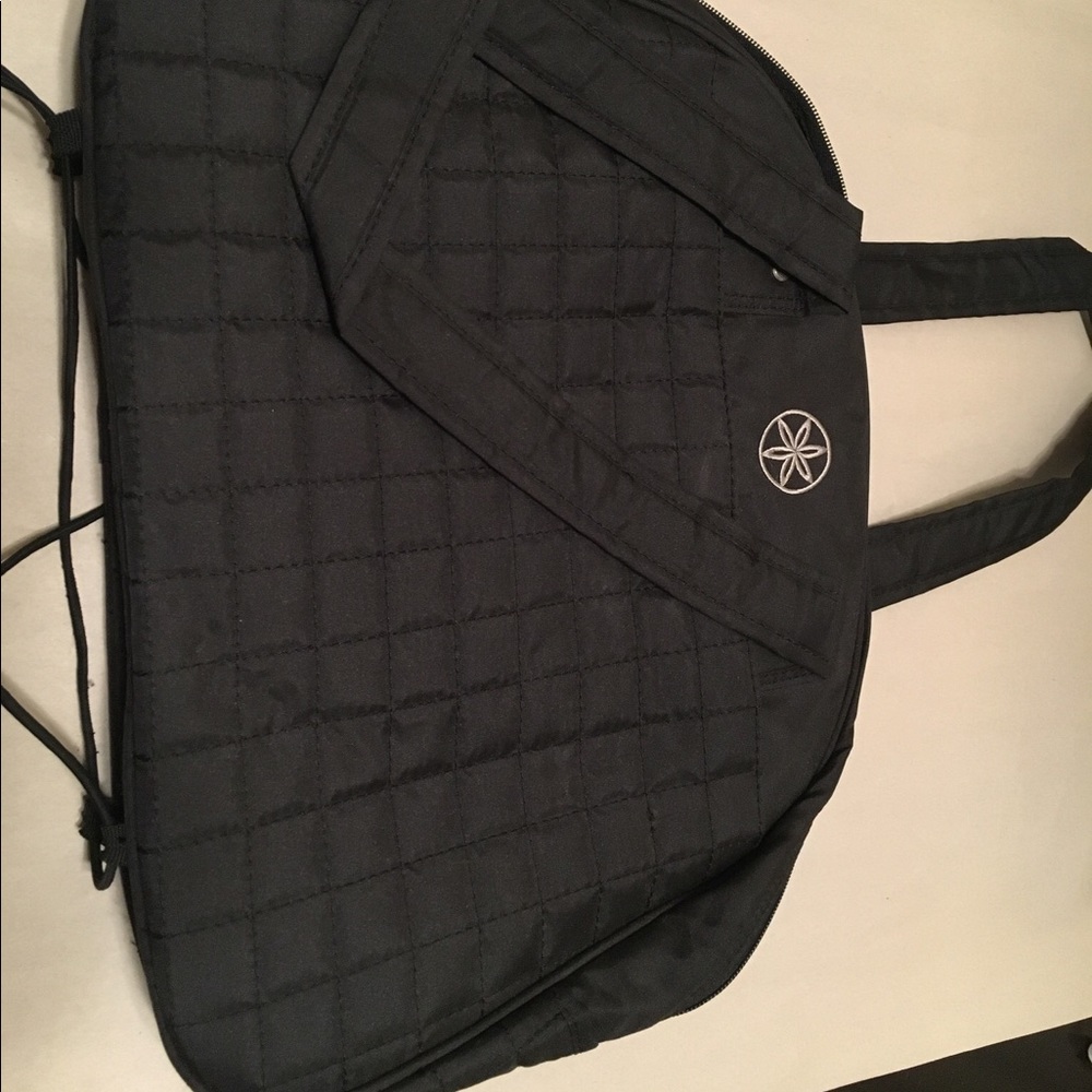 Black yoga bag with bungee to attach mat.